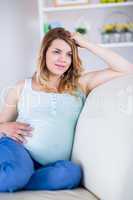 Pregnant woman looking away with hand in hair