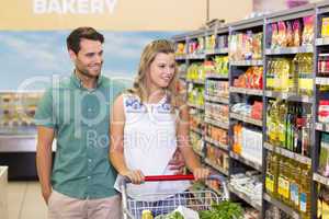 Bright couple buying products in aisle
