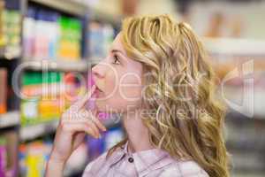 Side view on pretty blonde woman looking at shelf