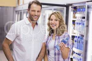 Portrait of a smiling casual couple having a water bottle