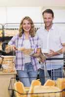 Portrait of a smiling casual couple taking a bread