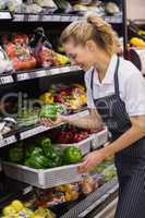 Smiling blonde worker taking a vegetables