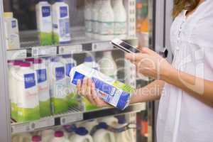 Woman taking picture of bottle of milk
