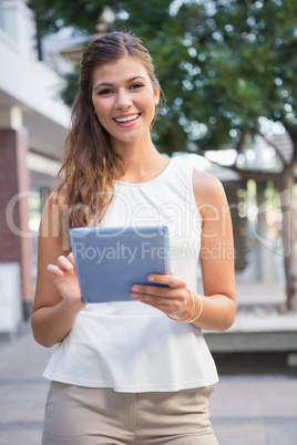 Portrait of smiling woman using tablet computer and looking at c Portrait of smiling woman using tablet computer and looking at c