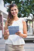 Portrait of smiling woman using tablet computer and looking at c