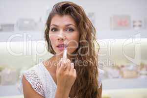 Portrait of woman testing lipstick