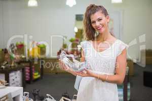 Portrait of smiling woman holding high-heeled sandal