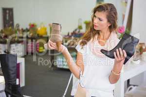 Woman having difficulties choosing shoes