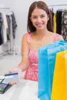 Portrait of smiling woman paying by credit card