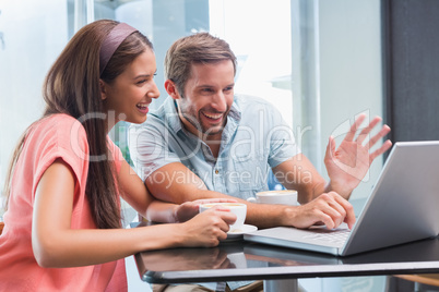 Young happy couple looking at a laptop