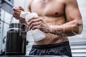 Muscular man making protein cocktail
