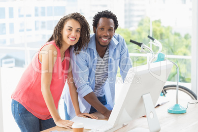 Two creative business colleagues discussing over a computer