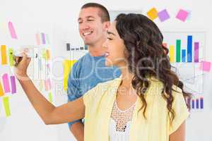 Smiling coworkers writing on sticky notes