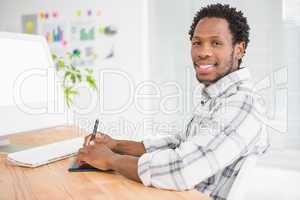 Young businessman writing on the graphic tablet