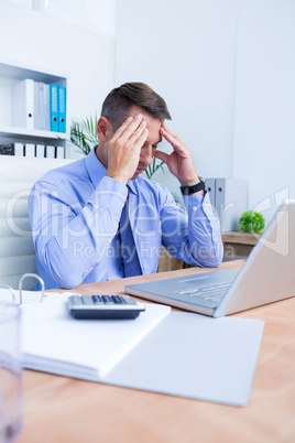 Businessman with severe headache holding his head