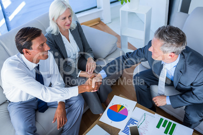 Business people shake hands on couch