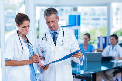 Doctors looking together at clipboard