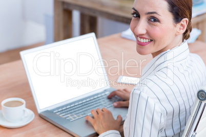 Brunette businesswoman smiling using laptop