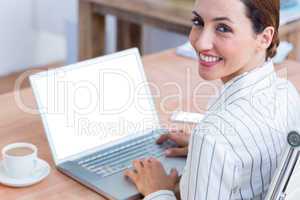 Brunette businesswoman smiling using laptop