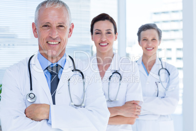 Portrait of three smiling medical colleagues with arms crossed