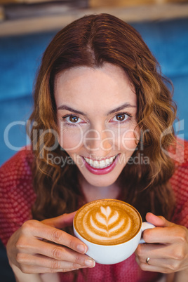 Casual brunette drinking coffee