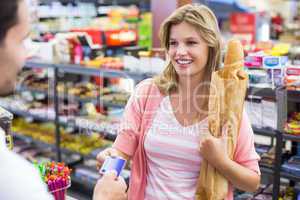 Smiling woman at cash register paying with credit card