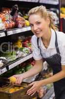 Portrait of a smiling blonde worker taking a lemon