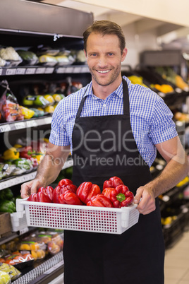 Portrait of a smiling handsome holding a box with vegetables