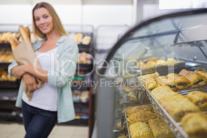 A woman buying bread in the pastries shelf