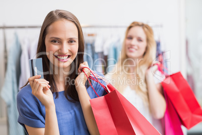 Happy friends holding a credit card