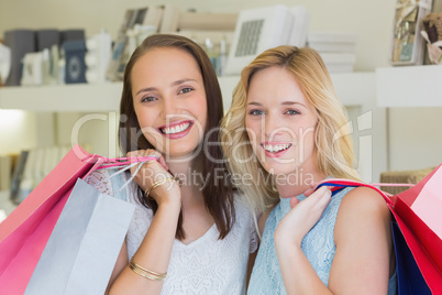 Happy women smiling at camera with shopping bags