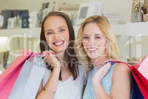 Happy women smiling at camera with shopping bags