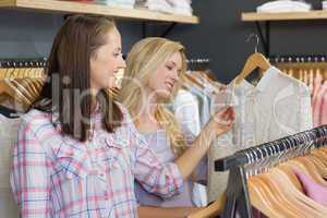 Two beautiful women touching a shirt