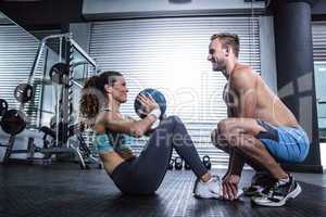 Muscular couple doing abdominal ball exercise