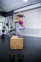 Muscular woman doing jumping squats