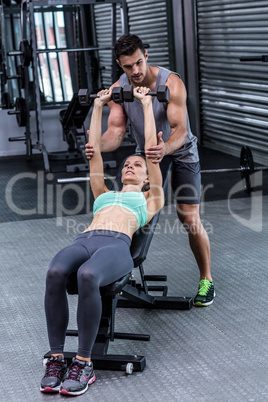 A muscular woman lifting dumbbells