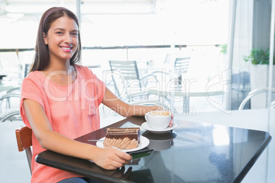 Young happy woman with cake and coffee