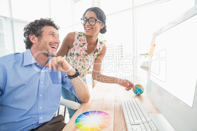 Casual businesswoman looking at colleagues computer