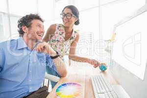 Casual businesswoman looking at colleagues computer