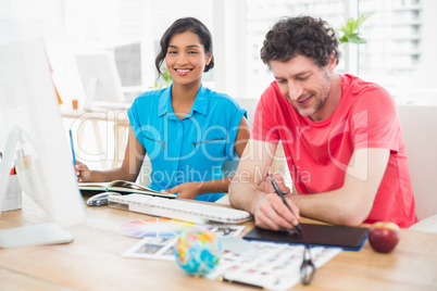 Smiling businessman using laptop and digitizer