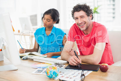 Smiling businessman using laptop and digitizer