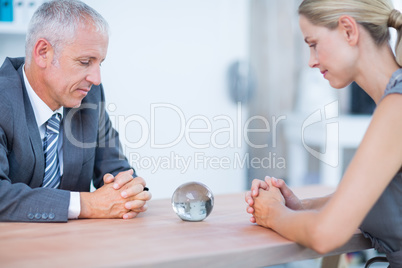 Two business people thinking with a crystal ball