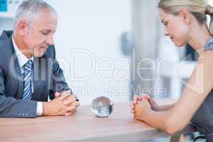 Two business people thinking with a crystal ball