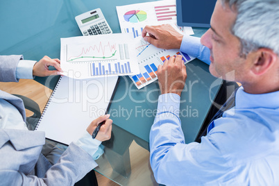 Business people looking at documents with graphics