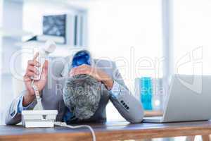 Depressed businessman holding phone