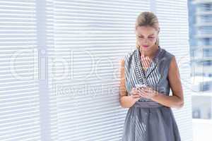 Concentrated businesswoman sending a text message