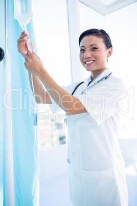 Female doctor connecting an intravenous drip