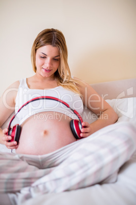 Pregnant woman relaxing on bed