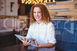 Pretty girl using a small tablet at table