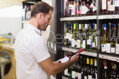 Handsome looking at wine bottle Handsome looking at wine bottle